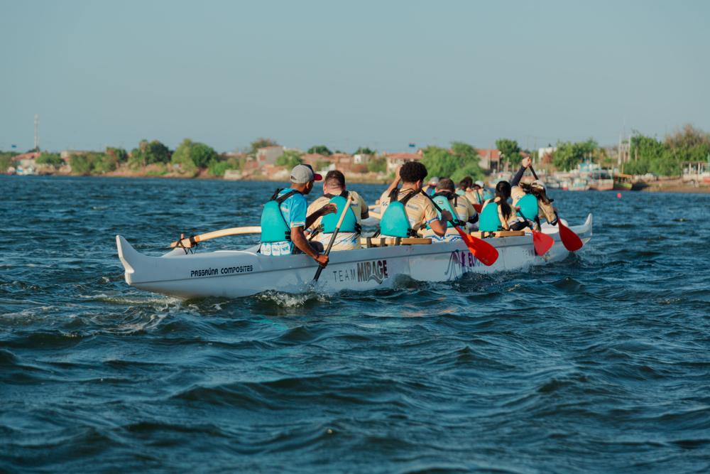 Equipe rema uma canoa havaiana OC6 no rio